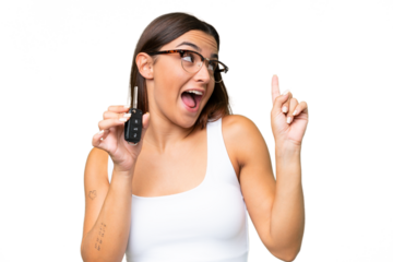 Young caucasian woman holding car keys isolated on green chroma background background intending to realizes the solution while lifting a finger up