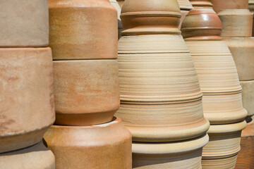 Pottery jugs, amphorae and other items of various shapes standing in an open space.