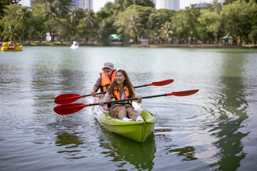 White father kayak with his young Asian adopted daughter wth laughing and smiling of fun and...