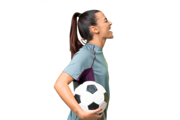 Young football player Woman over isolated chroma key background laughing in lateral position