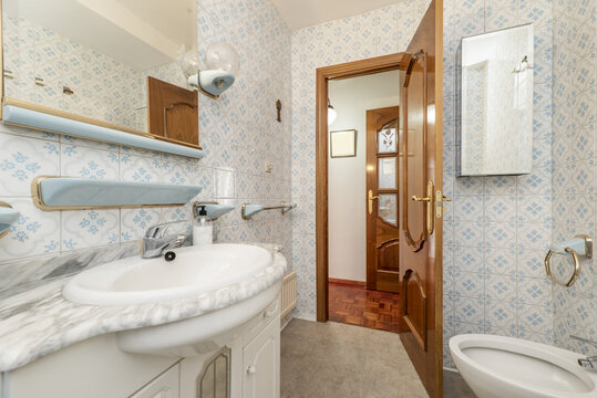 A slightly dated full bathroom with a square mirror