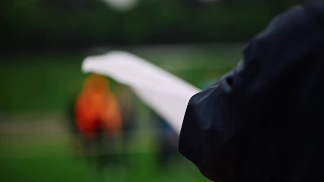 A referee at a track and field tournament holding a white flag, a good attempt. Slow motion