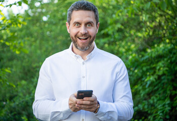 Obraz na płótnie Canvas amazed marketing businessman with phone work online. photo of marketing businessman with phone.