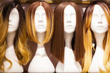 Women's wigs put on the heads of mannequins.