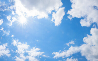 cloudy blue sky with bright sun and copy space in the middle
