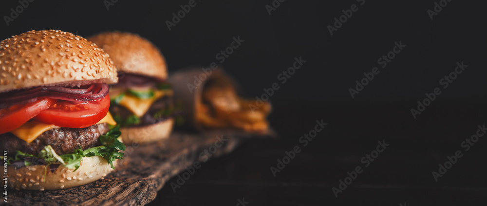 Wall mural two mouth-watering, delicious homemade burger used to chop beef. on the wooden table.