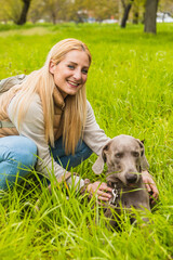 Portrait of weimaraner with his mistress in the park