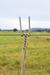 Focus on foreground smooth wire of a fence