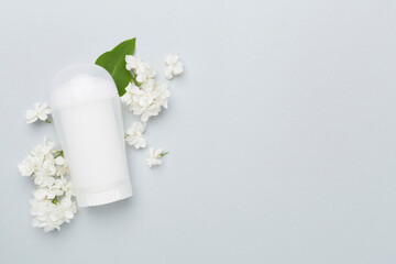 Composition with deodorant and flowers on color background, top view