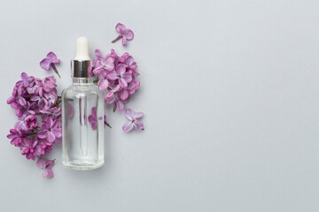 Face serum with flowers on color background, top view