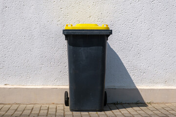 Yellow dustbin or trash can or black dustbin or trash can with yellow lid - obrazy, fototapety, plakaty