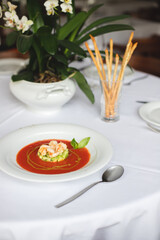 Appetizing Italian soup with seafood in a large white plate. Shrimps, mussels, octopuses. Restaurant serving food.