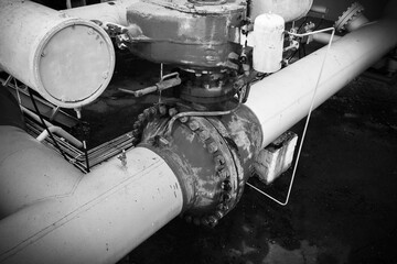 T-shaped joint and electric ball valve of an oil pipeline, compressor station, black and white photo.
