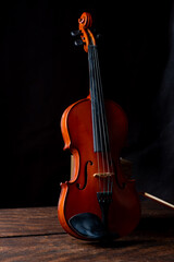 Fototapeta na wymiar Violin, details of a beautiful violin on rustic wood, low key style photo, black background, selective focus.
