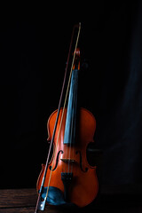 Violin, details of a beautiful violin on rustic wood, low key style photo, black background, selective focus. © Milton Buzon