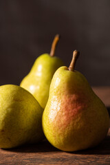 Pears, beautiful pears arranged on rustic wood with black background, selective focus.