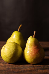 Pears, beautiful pears arranged on rustic wood with black background, selective focus.