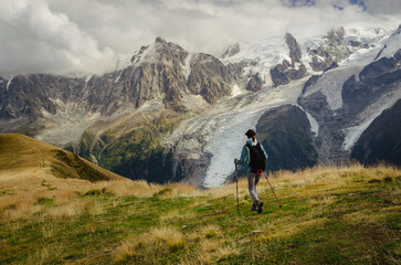 Fototapeta na wymiar Woman hiking in the mountains with a view of the Chamonix glacier and the Mont Blanc