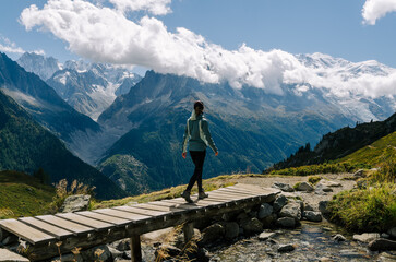 Woman hiking in the mountains with a view of the sea of ice and the Mont Blanc in Chamonix valley