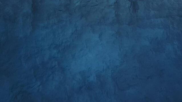 Aerial top down view of deep blue sea surface water, static shot