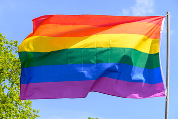 Gay pride rainbow colours flag and blue sky