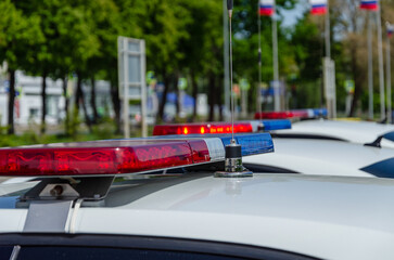 Police car flashing light. In the background, the flags of Russia are out of focus. © tinkerfrost
