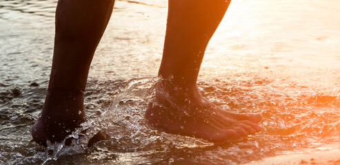 A man is running along the coast, training, legs and water closeup.