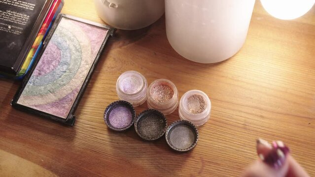 Shiny colorful eyeshadows and glitter on the table