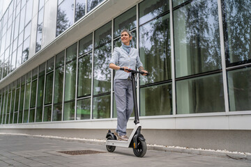 One woman mature senior adult female with eco electric kick scooter © Miljan Živković