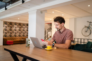 One modern caucasian man using mobile phone while stand at cafe