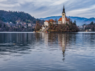 Lake Bled island church and bled town in the background during a cloudy afternoon, Bled, Slovenia