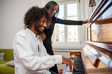 A boy plays a piano with his friend and they have fun, music class © Media Lens King