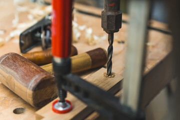 Carpenter drilling a hole in wooden plank using a traditional hand drill machine. High quality photo