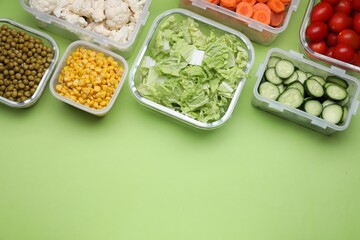 Plastic and glass containers with different fresh products on light green background, flat lay. Space for text