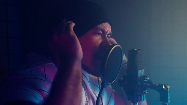 Energetic man singer recording track in music studio