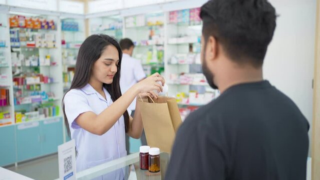 4K Attractive Indian woman pharmacist medication recommendation about medicine, drugs and supplements to man patient customer in modern drugstore. Medical pharmacy and healthcare providers concept.