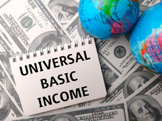 Earth globe and notebook with the word UNIVERSAL BASIC INCOME