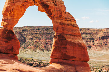 Peeking through the frame of a natural arch in Utah's red desert. A window into travel, adventure and landscape.