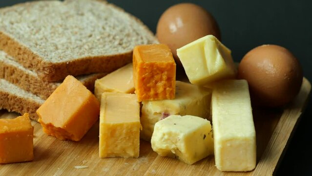 Cheese cubes green, yellow and red color on chopping board 