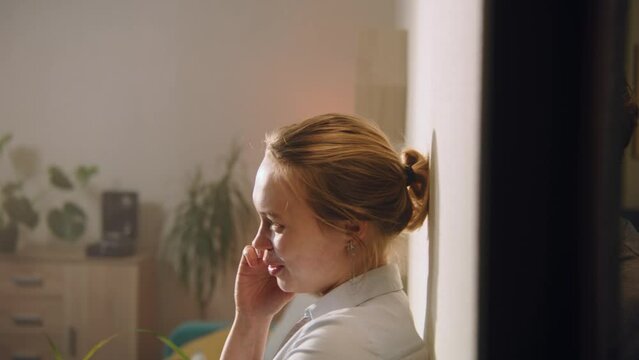 Adult man leans on the wall, eavesdrops on conversation. Woman talks by phone in the neighbor room or apartment. Apartment with thin walls, without sound insulation. Concept of neighbourhood.