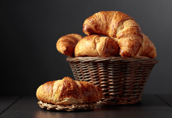 Fresh croissants on a black ceramic table.