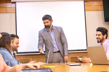 Indian businessman explaining project detail in a meeting to his partner or employee.