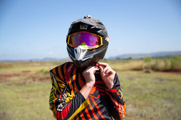 Dirt Biker Putting on Helmet