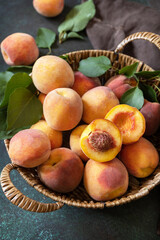 Naklejka na ściany i meble Harvest background. Organic fruits. Farmer's market. Basket of ripe peaches on a stone table.