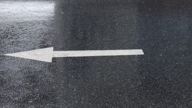 Road Marking One Way Arrow With Heavy Rainfall Falling On Road Surface