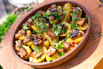 Baked potato slices with bacon, herbs, spices and pomegranate seeds.