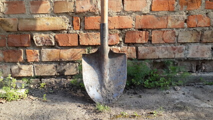 old dirty shovel on brick wall background. garden tools equipment. agriculture tool concept 