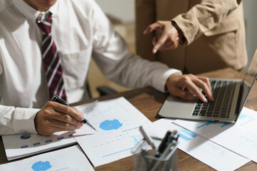 Two business reading business document to brainstorming about new startup and typing data on laptop