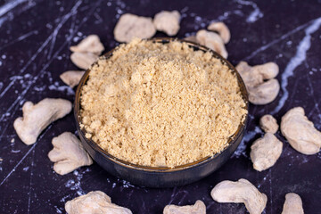 Ginger powder on dark background. Powdered dried ginger in bowl