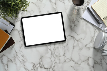 Top view of digital tablet with white empty screen, headphone and coffee cup on marble background